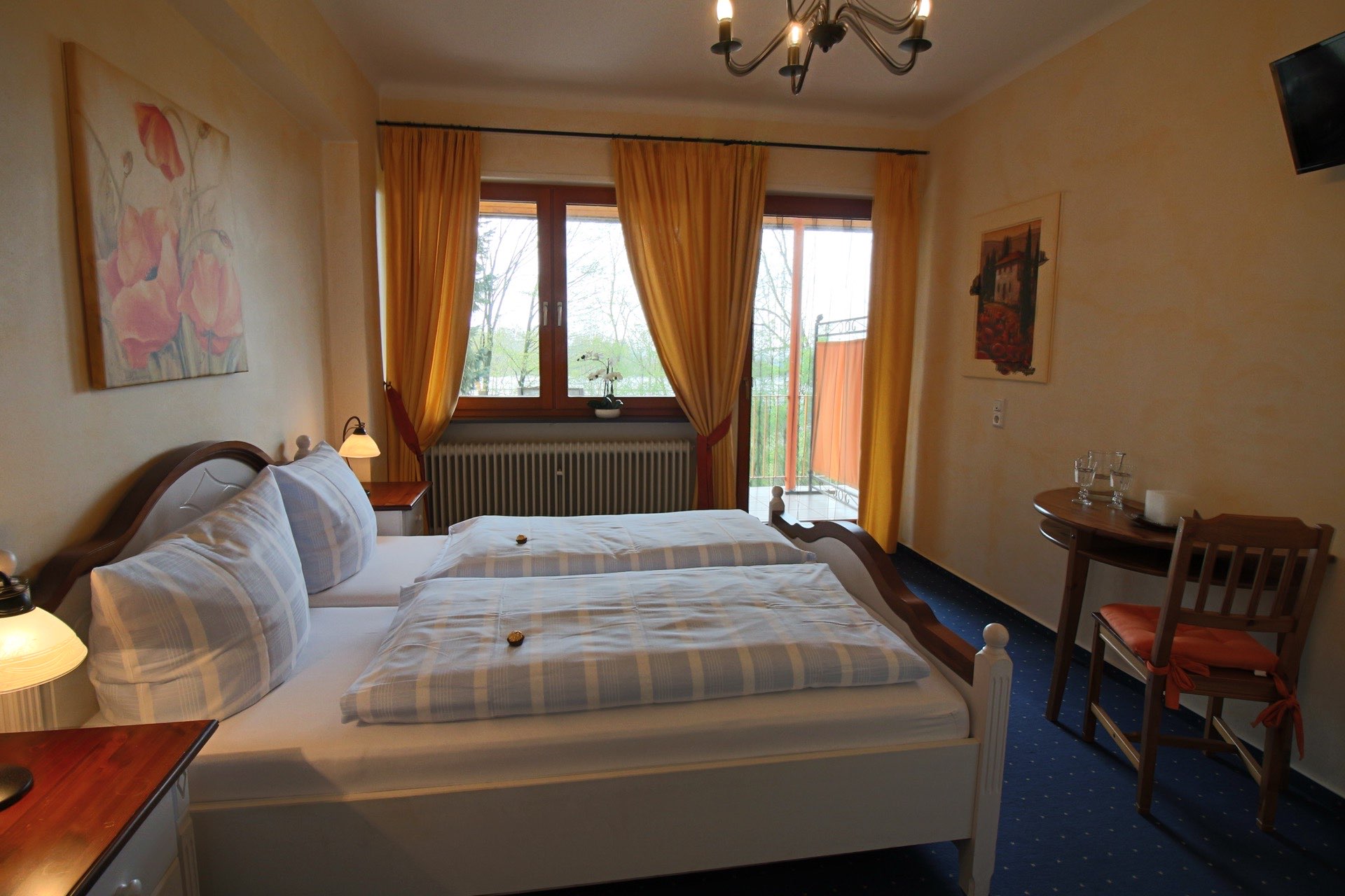 Helles Doppelzimmer in der Pension Rehwinkel in Nalbach, mit großen Fenstern, gelben Vorhängen und einem eleganten Ambiente.